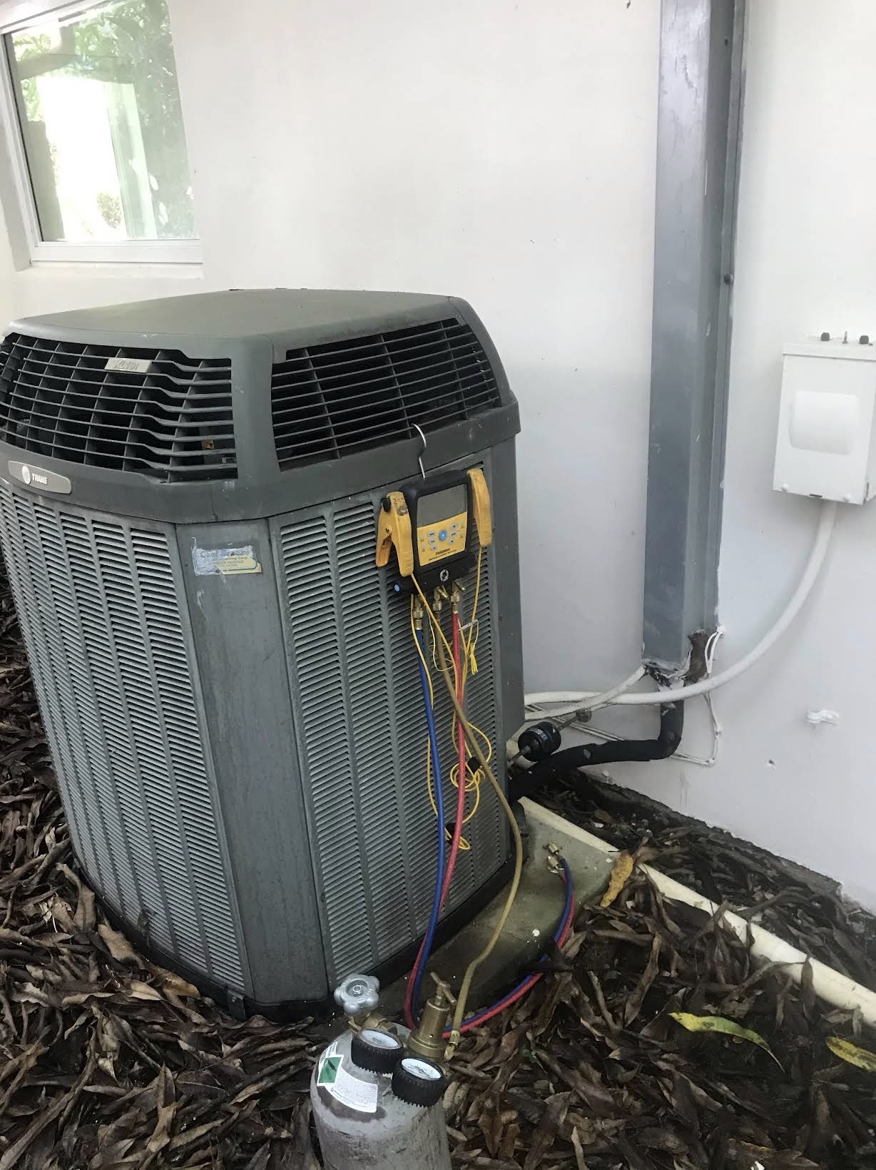 Refrigerant gauges hooked to a Trane condenser during a service call