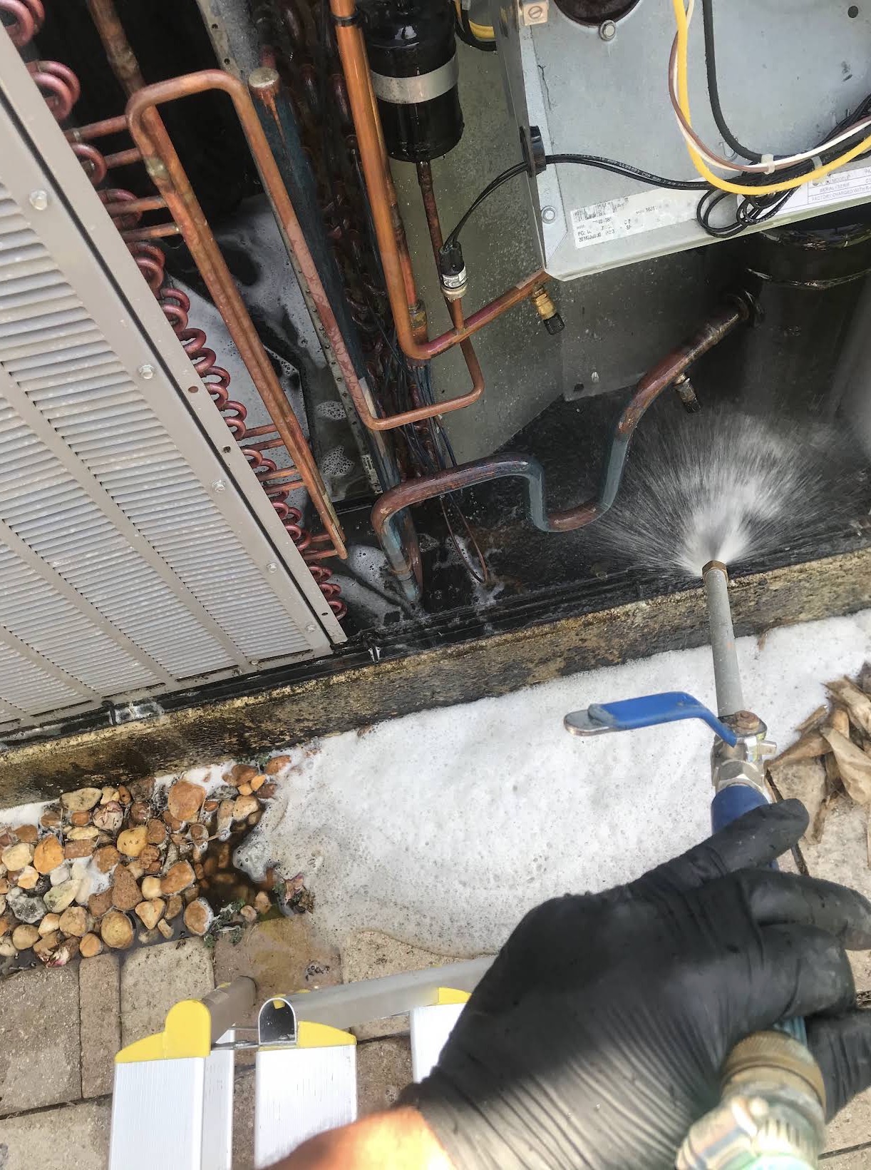 Foaming coil cleaner applied during a condenser wash-down
